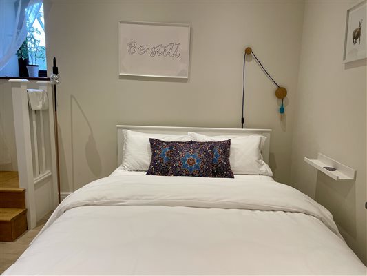 The third bedroom, King Size Bed with white bed linen and three purple cushions.